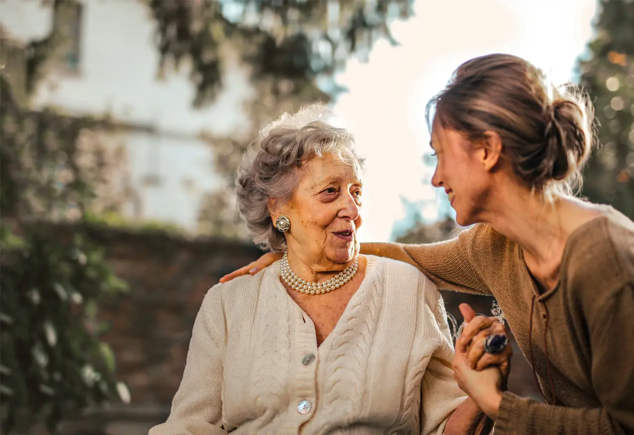 A woman and an old lady smiling for the camera.